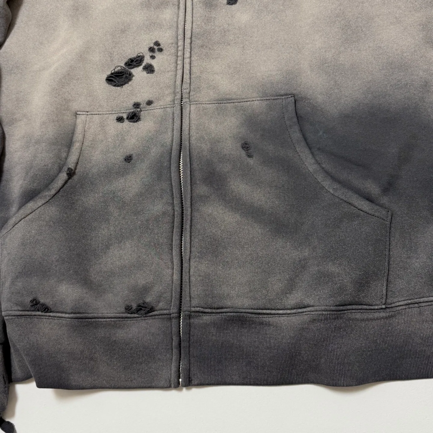 More details SAINT Mxxxxxx DBL FACE ZIP UP HOODIE/CHARCOAL Double-layer destroyed waffle zipper jacket, washed black S-XL, a style that has been used in the summer. After continuous fine polishing, it is finally shipped. The finished product is simply a work of art. Super heavy washing and distressing, multiple horse water fading, many hand-made wormhole destruction processing, deconstruction and reorganization embroidery technology, custom-made zipper with LOGO, and the color details of the zipper webbing are also correct. Original grade fruit main label and wash water label. Top purchasing grade. A layer of waffle fabric is added to the inner lining to make the overall texture stronger and increase the comfort and warmth of the wearer.